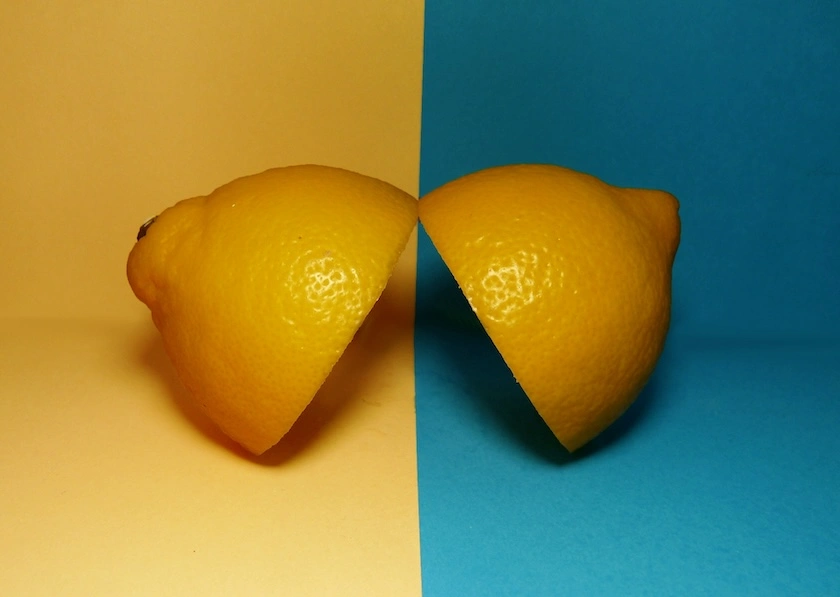 Un citron découpé sur un fond moitié jaune moitié bleu