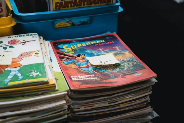 Piles de bandes dessinées d'occasion étiquetées 3 euros sur un stand de vide-grenier, une action de financement classique pour une association de parents d'élèves